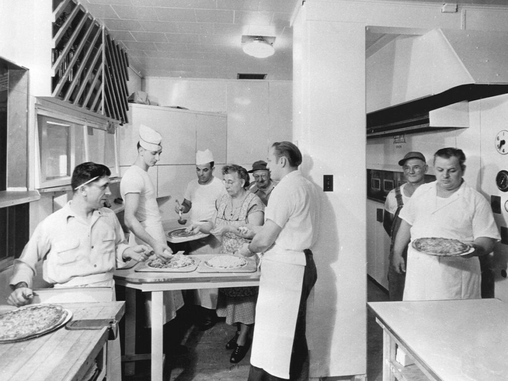 Black and white photo of family making the original pizza recipe